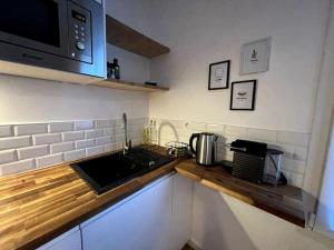 um balcão de cozinha com um lavatório e um micro-ondas em Studio 3 - Mi-Côte - Studio à Orvault em Orvault