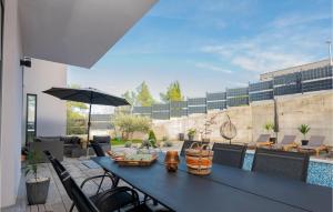 patio ze stołem, krzesłami i parasolem w obiekcie Gorgeous Home In Vrgorac With Outdoor Swimming Pool w mieście Vrgorac