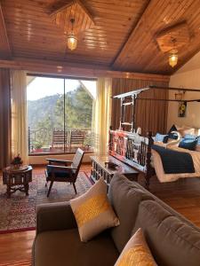 a living room with a couch and a bed at Chillaru Spa & Resort in Kasauli