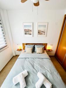 a bedroom with a large bed with two towels on it at Apartamento con Piscina y Jardín Fantástico Cala Sirenas - Nuevo in Miami Platja