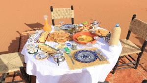 a table with a plate of food on it at Sahara Relax Camps in Zagora