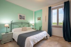 een slaapkamer met een bed en een groot raam bij Ombra Verde Residence e B&B in Follonica