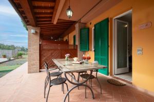 une terrasse couverte avec une table et des chaises. dans l'établissement Ombra Verde Residence e B&B, à Follonica