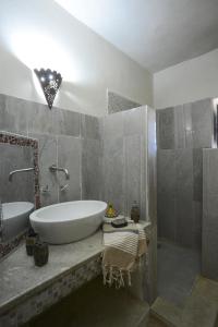 a bathroom with a tub and a sink and a shower at Dar Almassa in Mellita