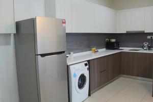 a kitchen with a refrigerator and a washing machine at Sausana Suites D' Bliss in Johor Bahru