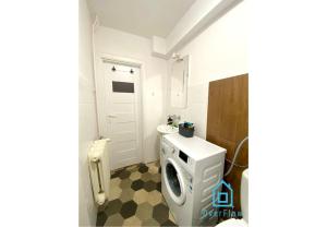 a bathroom with a toilet and a washing machine at Lovely Room in Gdańsk