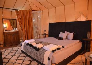 ザゴラにあるSahara Relax Campsのテント内の大型ベッド付きのベッドルーム1室