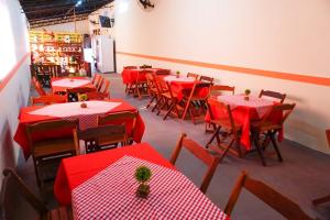 een restaurant met rode tafels en stoelen met rode tafelkleden bij Pousada dos Chalés in Olímpia