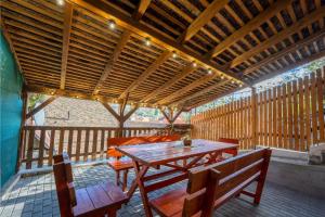 a patio with a wooden table and benches on a deck at Casa Maya Transilvania in Sighişoara