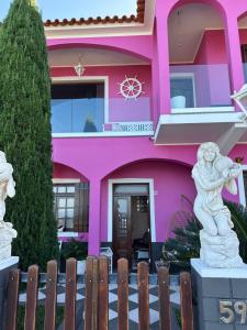 a pink house with a statue in front of it at Residência Mendonça in Faial