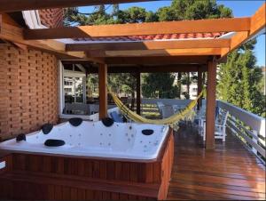 bañera de hidromasaje en una terraza con hamaca en Villa Dal Maso, en Campos do Jordão
