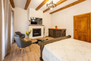 a bedroom with a bed and a chair and a fireplace at Casa Maya Transilvania in Sighişoara