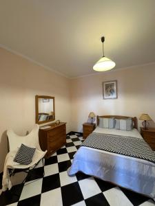 a bedroom with a bed and a checkered floor at Residência Mendonça in Faial
