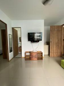 een woonkamer met een flatscreen-tv aan de muur bij Condominio Paraíso del Sol in San Jerónimo