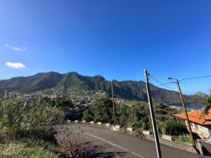 una strada vuota con una montagna sullo sfondo di Residência Mendonça a Faial
