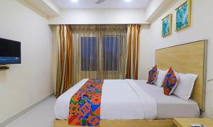 a bedroom with a bed and a television in it at FabHotel Swarnas in Vijayawāda