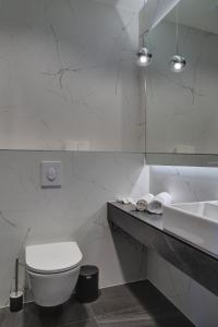 a white bathroom with a toilet and a sink at Avenue21 in Zagreb