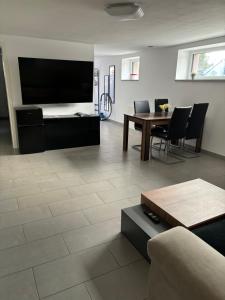 a living room with a tv and a table and chairs at Ferienwohnung Annashome in Maxhütte-Haidhof