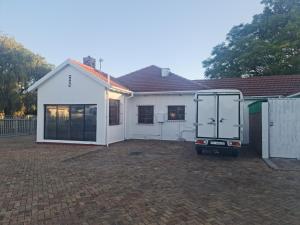 una casa blanca con patio trasero en HASATE GUEST HOUSE 13 LOUWVILLE STREET BELLIVILLE Cape Town south Africa, en Ciudad del Cabo