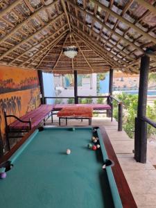 a pool table in a patio with a table and benches at Keur Medzo - Lac Rose in Niaga