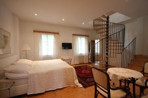 a bedroom with a bed and a spiral staircase at Alter Winzerkeller in Kirchberg am Wagram