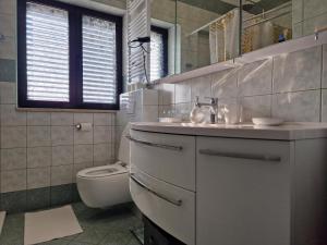 Baño blanco con aseo y lavamanos en Paradise, en Pula
