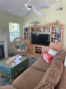 a living room with a couch and a flat screen tv at Escape to an island adventure! Free bikes & beach items in Anna Maria