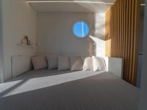 sypialnia z dużym łóżkiem i okrągłym oknem w obiekcie La Maison de la Mer Sotogrande w mieście Sotogrande