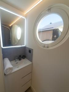 a bathroom with a sink and a round window at La Maison de la Mer Sotogrande in Sotogrande