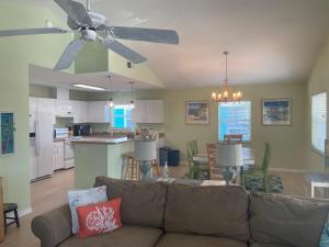 a living room with a couch and a ceiling fan at Escape to an island adventure! Free bikes & beach items in Anna Maria