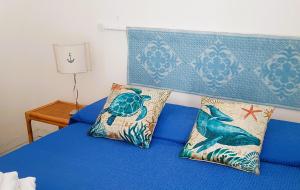 a blue bed with two pillows on top of it at Rosa dei venti in Stintino