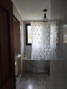 bagno con vasca, servizi igienici e finestra di Maison familiale de vacances a Serres