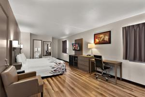 a hotel room with a bed and a desk and chair at Red Roof Inn Winchester, VA in Winchester +28 photos
