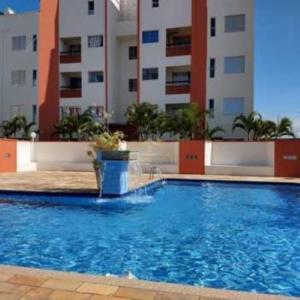 une grande piscine en face d'un bâtiment dans l'établissement Apartamento em Itanhaém com 2 quartos, Piscina e Ampla Varanda Gourmet, à Itanhaém