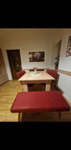 a wooden table with red chairs and a red bench at Ap Central Traian Moșoiu 2 Parcare proprie in Cluj-Napoca