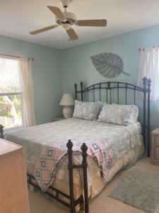 a bedroom with a bed and a ceiling fan at Escape to an island adventure! Free bikes & beach items in Anna Maria