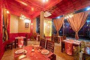 un restaurante con mesas y sillas en una habitación en Shalom Corbett’s Hillside Hideaway, en Belparāo