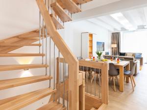 un salon avec un escalier et une salle à manger dans l'établissement FeWo Prora - Strandjuwel, à Binz
