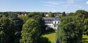 una vista aerea di una grande casa bianca tra gli alberi di Gästehaus im Schlosspark 