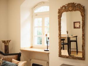 specchio in soggiorno con tavolo di Gästehaus im Schlosspark 