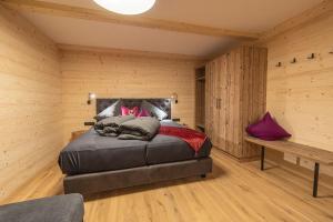 a bedroom with a bed in a room with wooden walls at Grubi´s Chalet Alm in Gerlos