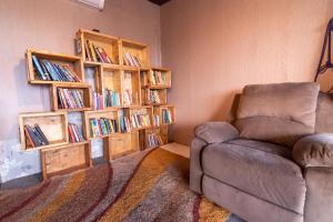 una sala de estar con sofá y estanterías con libros en Shalom Corbett’s Hillside Hideaway, en Belparāo