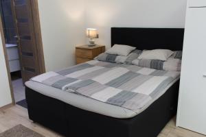 a bedroom with a large bed with a striped blanket at Silver Dream Apartman in Debrecen