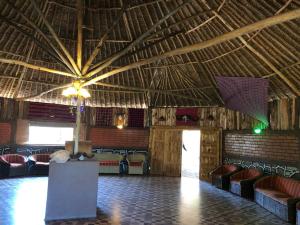 Eco Mara Tented Camp في Ololaimutiek: غرفة كبيرة مع كراسي وسقف كبير