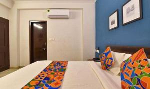 a bedroom with a bed and a blue wall at FabHotel Gangashrey in Jaipur