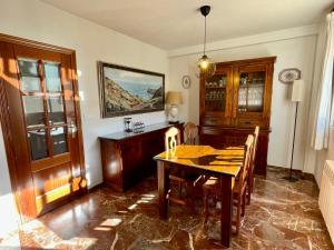 uma sala de jantar com uma mesa de madeira e cadeiras em Casa rural Lomalinda em Granada
