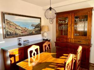 uma sala de jantar com uma mesa de madeira e um lustre em Casa rural Lomalinda em Granada