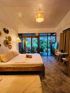 a bedroom with a large bed and a chandelier at Dee Siargaonon Homestay in General Luna