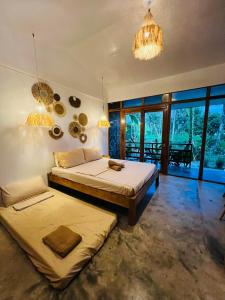 a bedroom with two beds and a chandelier at Dee Siargaonon Homestay in General Luna