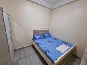 Schlafzimmer mit einem Bett mit blauer Bettwäsche und blauen Kissen in der Unterkunft Keur Coumba in Dakar